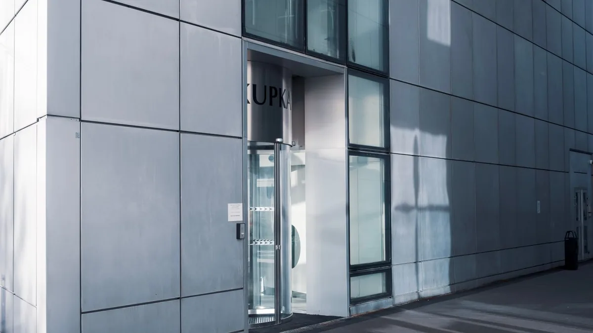 Entrée vitrée d'un bâtiment professionnel moderne à la façade grise